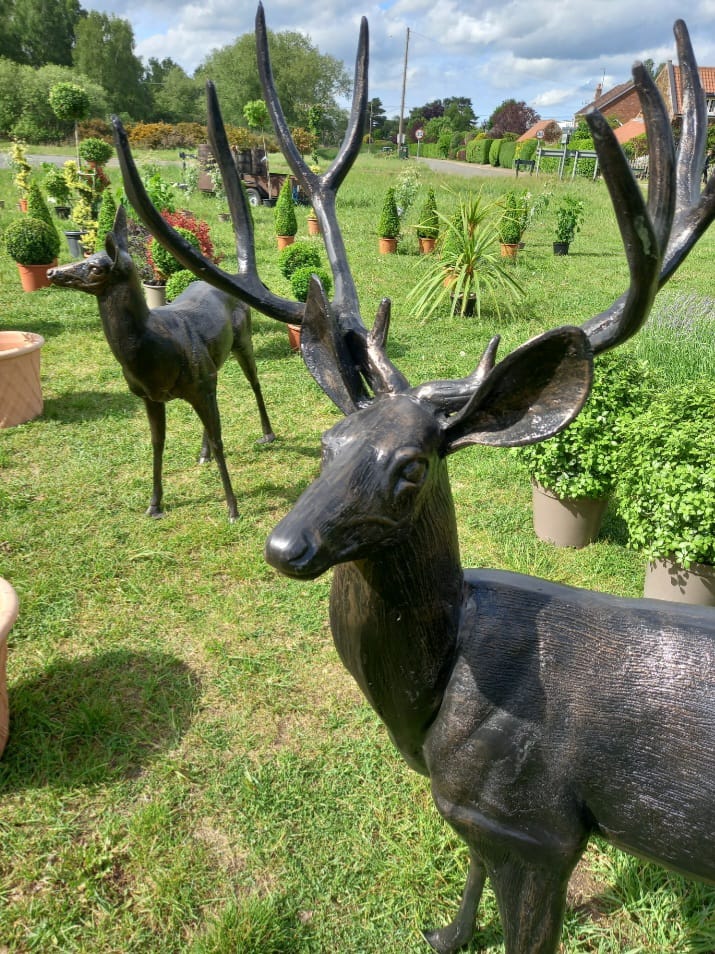 Multiple deer statues in garden